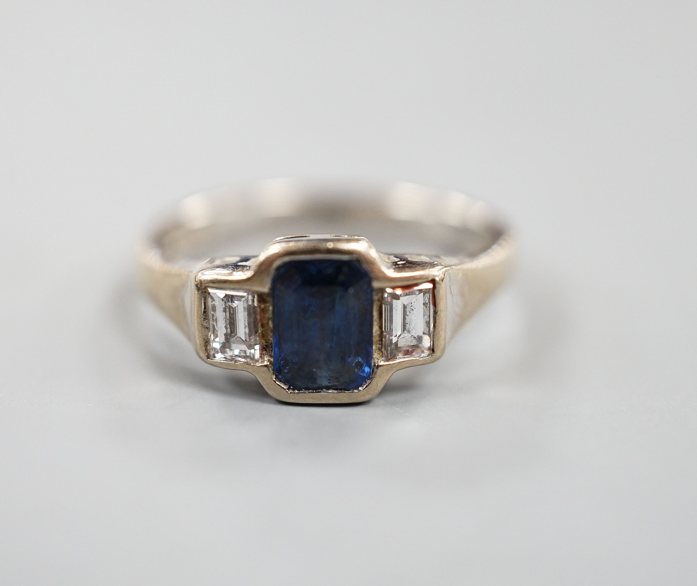 A modern 18ct white gold, collet set sapphire and diamond three stone ring, size L, gross weight 3.8 grams.